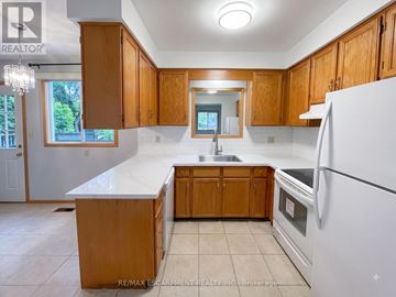 Hamilton (Eastmount) apartment for rent - A kitchen with wooden cabinets and a white countertop.