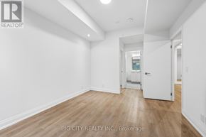 Toronto (Thorncliffe Park) condo for rent - A room with white walls and wooden flooring, with a doorway leading to another room.