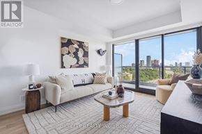 Toronto (Thorncliffe Park) condo for rent - A living room with a couch, a coffee table, and a large window overlooking the city.