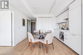 Toronto (Thorncliffe Park) condo for rent - A modern kitchen with white cabinets and a dining table with chairs.