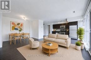 Toronto (Niagara) condo for rent - A living room with a couch, chairs, and a dining table.