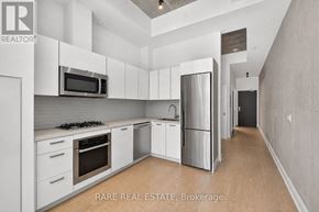 Toronto (Waterfront Communities) condo for rent - A modern kitchen with white cabinets and stainless steel appliances.
