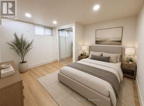 Whitby (Downtown Whitby) apartment for rent - A bedroom with a large bed, a nightstand, and a plant.