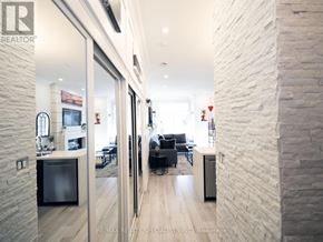 Mississauga (City Centre) condo for rent - A modern living room with a kitchen area in the background.