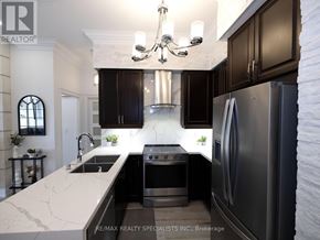Mississauga (City Centre) condo for rent - A modern kitchen with dark brown cabinets and a white marble countertop.