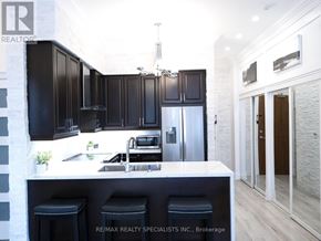 Mississauga (City Centre) condo for rent - A modern kitchen with black cabinets and a white island.
