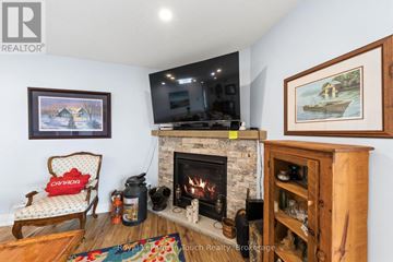 Tiny apartment for rent - A living room with a fireplace, a chair, and a painting on the wall.