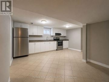 Mississauga (Clarkson) apartment for rent - A kitchen with white cabinets and a stainless steel refrigerator.