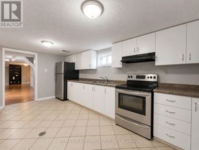Mississauga (Clarkson) apartment for rent - A kitchen with white cabinets and a black stove top oven.