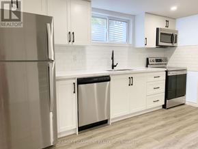 Brantford apartment for rent - A kitchen with white cabinets and a stainless steel refrigerator.