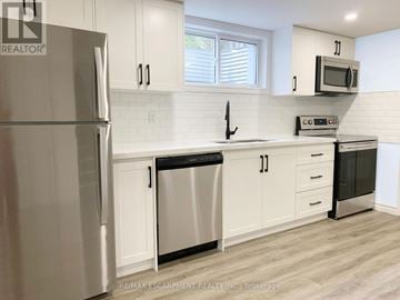 Brantford apartment for rent - A kitchen with white cabinets and a stainless steel refrigerator.