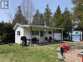 Goulais River apartment for rent - A house with a white exterior and a red grill on the patio.