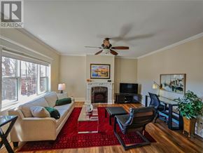 St. John's multi-family for rent - A living room with a fireplace, a couch, a chair, and a television.