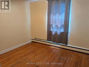 Oshawa (Lakeview) condo for rent - A room with wooden flooring and a window with curtains.