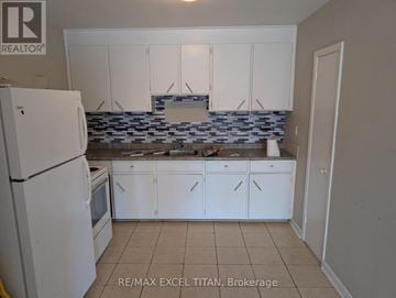 Oshawa (Lakeview) condo for rent - A kitchen with white cabinets and a white refrigerator.