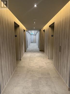 Vaughan (Vaughan Corporate Centre) condo for rent - A long hallway with doors on both sides and a carpeted floor.