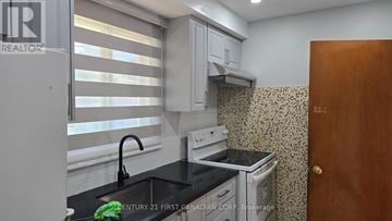 London South (South J) apartment for rent - A kitchen with a stove, sink, and cabinets.