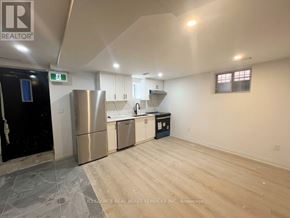 Toronto (University) apartment for rent - A kitchen area with a refrigerator, sink, and cabinets.