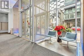 Toronto (Waterfront Communities) condo for rent - A glass door entrance to a building with a sign that says "NORTH 2 SOUTH REALTY Brokerage".