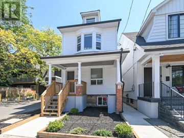 Toronto (The Beaches) triplex for rent - A white two-story house with a front porch and a small garden.