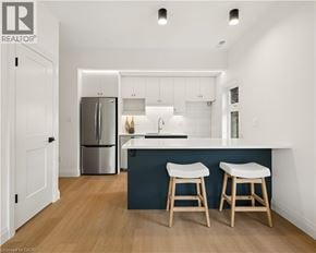 Kitchener apartment for rent - A kitchen with white cabinets and a dark blue island.