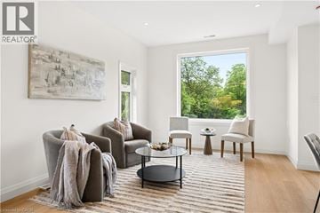 Kitchener apartment for rent - A living room with a large window and a painting on the wall.
