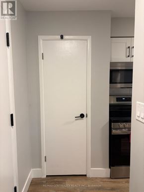 London South (South J) multi-family for rent - A white door in a kitchen with a stove and oven underneath it.