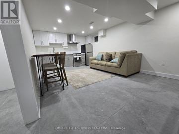Toronto (Agincourt South-Malvern West) apartment for rent - A realtor logo is on the wall in a modern kitchen and living room.