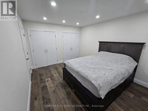 Toronto (Agincourt South-Malvern West) apartment for rent - A bedroom with a bed, wooden floors, and white walls.