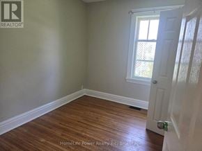 Guelph (St. Patrick's Ward) apartment for rent - A room with wooden flooring and a white door.