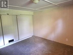 Guelph (St. Patrick's Ward) apartment for rent - A room with a carpeted floor and a white ceiling with a light fixture.