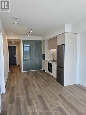 Mississauga (Cooksville) condo for rent - A modern kitchen with wooden flooring and white walls.