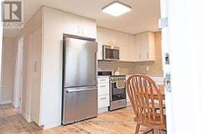 St. Catharines (Western Hill) apartment for rent - A kitchen with a refrigerator, oven, and microwave.