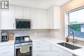 St. Catharines (Western Hill) apartment for rent - A kitchen with white cabinets and a black stove top.