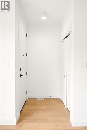 Kitchener apartment for rent - A hallway with a wooden floor and white walls.