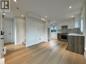 Vancouver apartment for rent - A spacious kitchen with a wooden floor and a stainless steel oven.