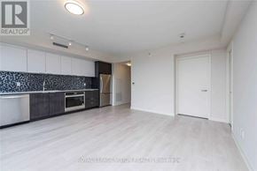 Toronto (Flemingdon Park) condo for rent - A spacious room with a kitchen area and a door to another room.