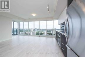 Toronto (Flemingdon Park) condo for rent - A spacious, empty room with a large window overlooking a cityscape.