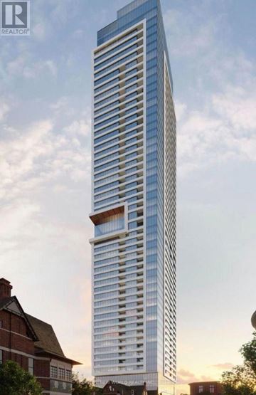 Toronto (North St. James Town) condo for rent - A tall, modern skyscraper stands in the foreground of a cityscape.