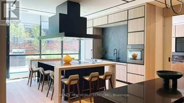 Toronto (North St. James Town) condo for rent - A modern kitchen with wooden cabinets and a black range hood.