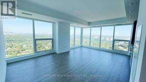 Toronto (North St. James Town) condo for rent - A spacious room with large windows overlooking a cityscape.