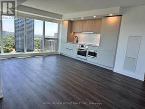 Toronto (North St. James Town) condo for rent - A spacious kitchen with dark wood flooring and a view of the city.