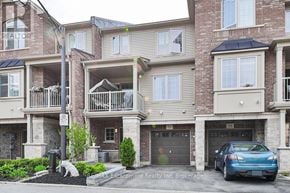 Grimsby (Grimsby Beach) townhouse for rent - A blue car is parked in front of a building with a sign that says "Escarpment Realty Inc, Brokerage".