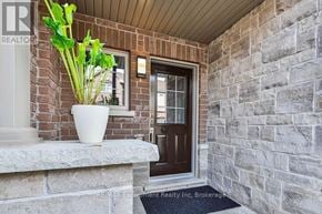 Grimsby (Grimsby Beach) townhouse for rent - A white vase with green plants sits on a stone ledge outside a house.