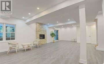 Pickering (Liverpool) apartment for rent - A spacious living room with a stone fireplace and a dining table set up.