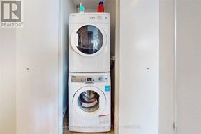 Toronto (Bay Street Corridor) condo for rent - A white washer and dryer stacked on top of each other in a small laundry room.