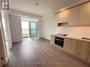 Vaughan (Concord) condo for rent - A spacious kitchen with wooden cabinets and a large window.