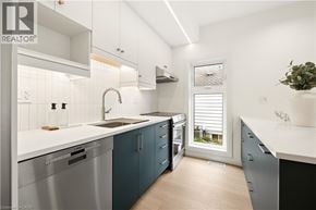 Kitchener apartment for rent - A modern kitchen with a white countertop and blue cabinets.