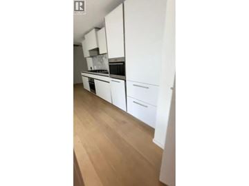 Vancouver apartment for rent - A kitchen with white cabinets and a wooden floor.