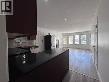 Vancouver apartment for rent - A modern kitchen with dark brown cabinets and a black countertop.